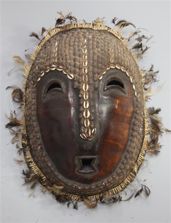 A Solomon Islands turtle shell mask, applied with shells and feathers, 42cm